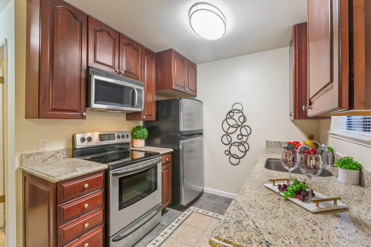 2250 Monroe Street, Unit 111 Santa Clara, CA 95050 - Photo 8 of 20 a kitchen with stainless steel appliances granite countertop a stove a microwave and cabinets