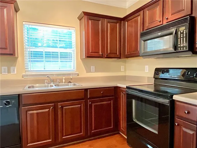 a kitchen with granite countertop cabinets stainless steel appliances a sink and window
