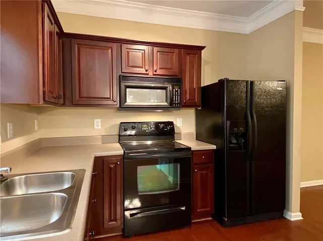 a kitchen with granite countertop a refrigerator stove and microwave