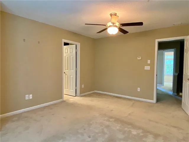 a view of an empty room with a ceiling fan