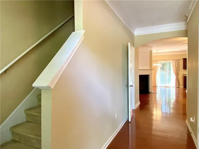 a view of a hallway with wooden floor and staircase