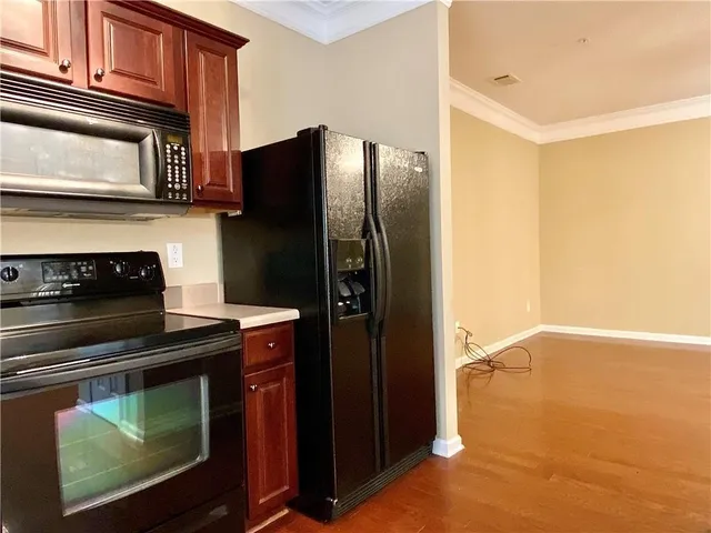 a kitchen with granite countertop a refrigerator stove and microwave