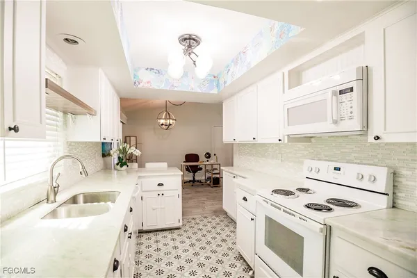 a kitchen with a sink a stove and cabinets