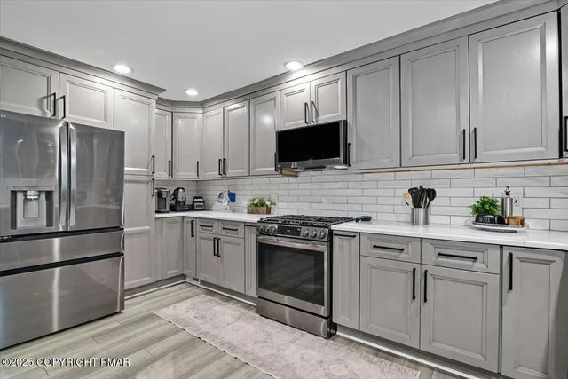 a kitchen with white cabinets stainless steel appliances and sink