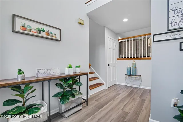 a view of a hallway with wooden floor and a potted plant