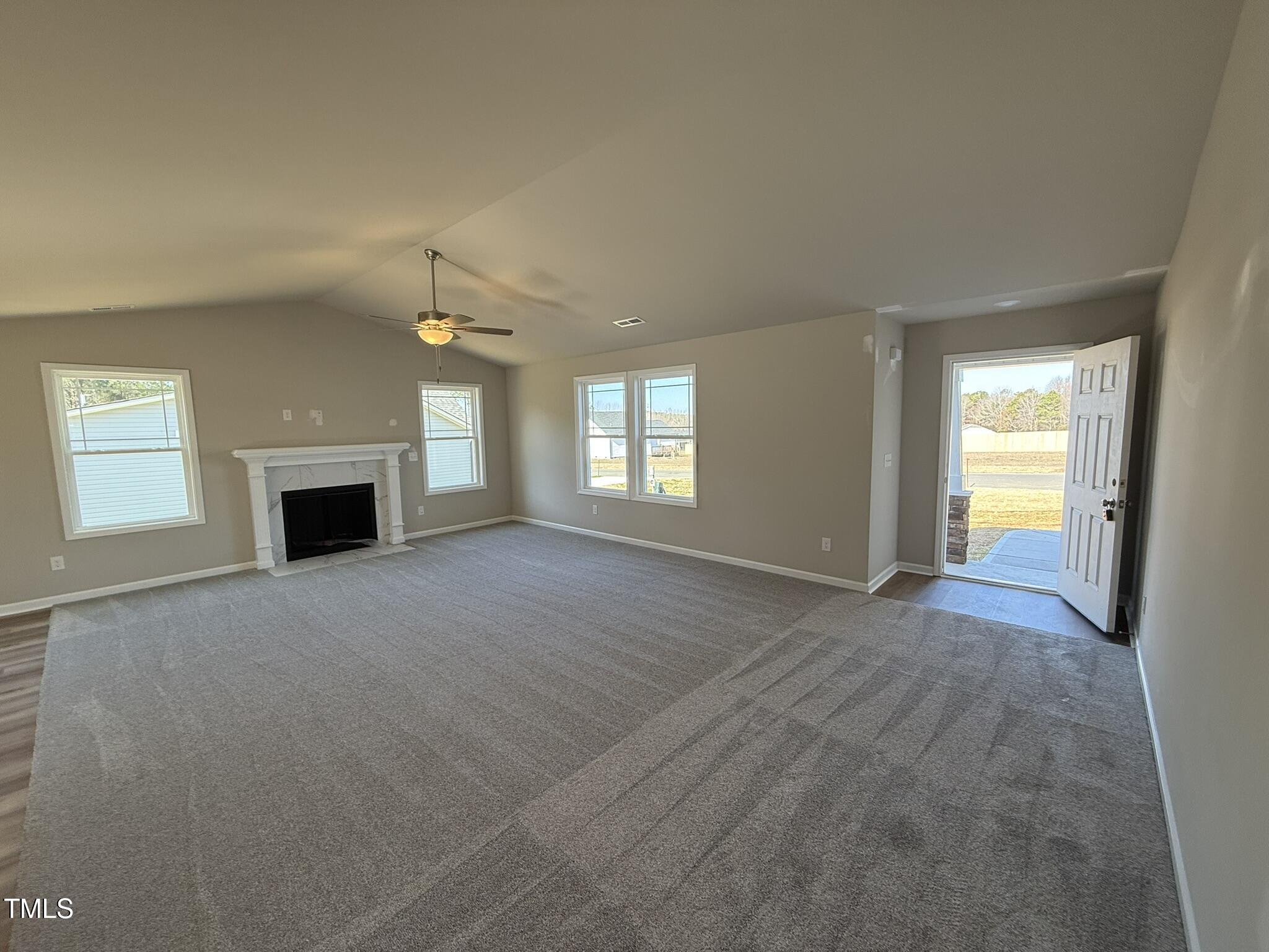 175 Magnolia Run Way Benson, NC 27504 - Photo 3 of 19 an empty room with windows and fireplace