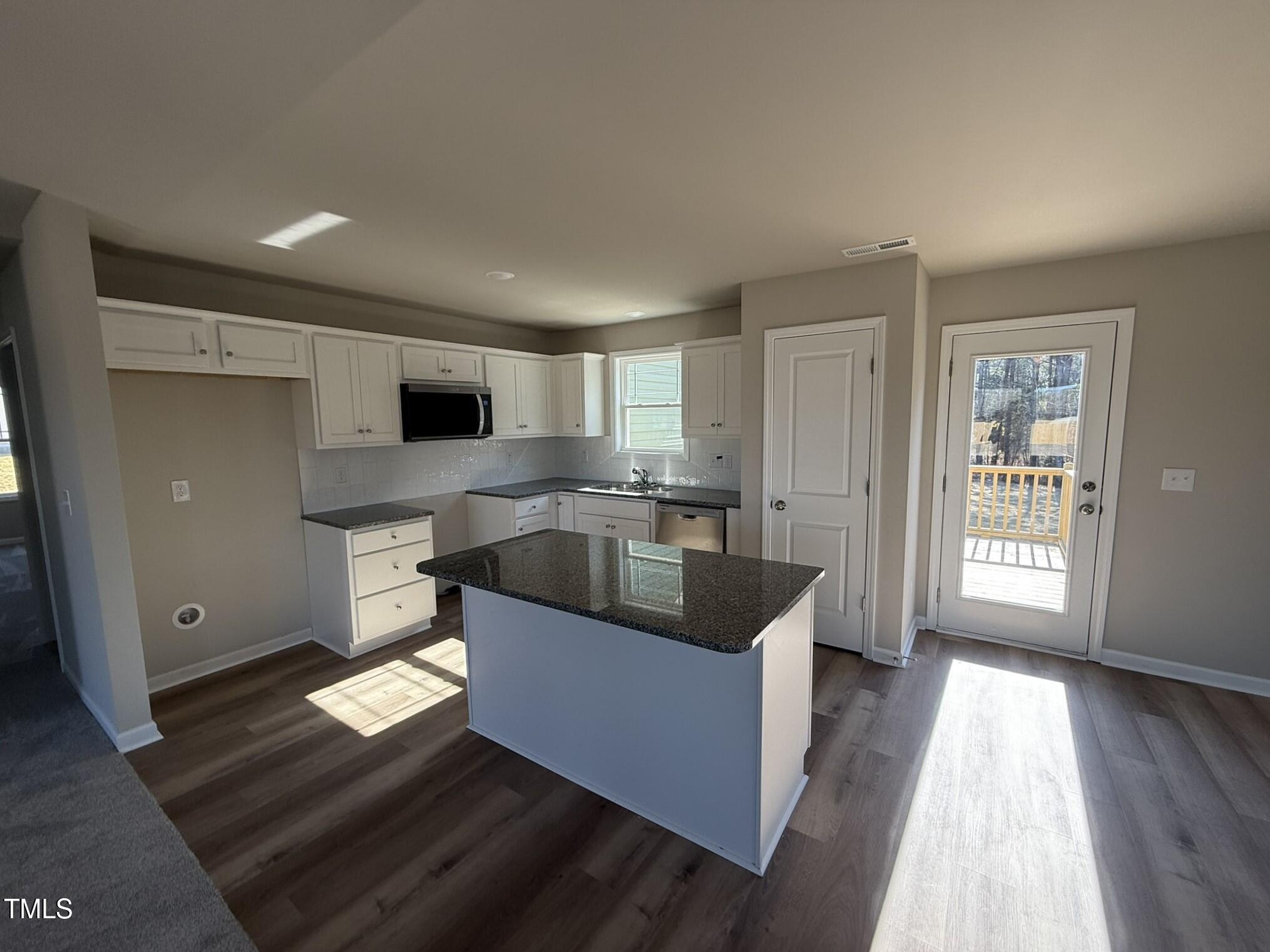175 Magnolia Run Way Benson, NC 27504 - Photo 9 of 19 a kitchen with stainless steel appliances granite countertop a sink a stove and a refrigerator