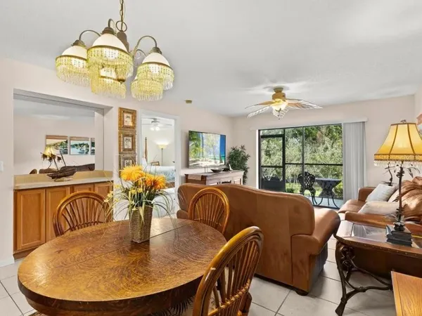 a view of a dining room with furniture a chandelier and window