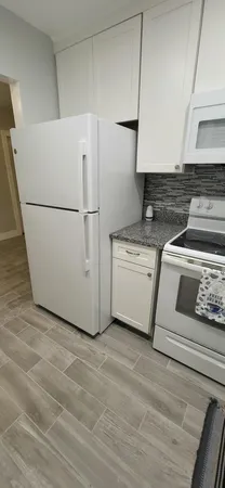 a view of kitchen with granite countertop cabinets