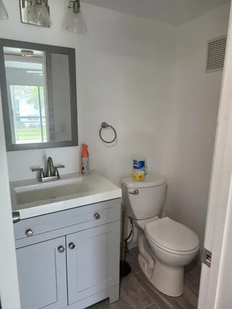 a bathroom with a toilet sink and mirror