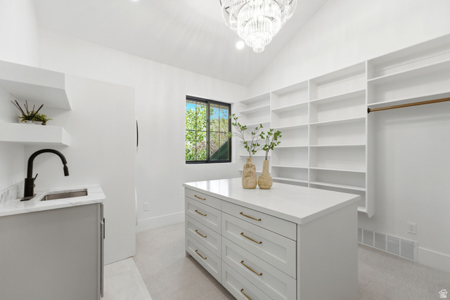 3027 Homestead Road Park City, UT 84098 - Photo 31 of 62 Vaulted ceilings with a chandelier illuminate this space featuring a built-in island with storage, extensive built-in shelving, a dedicated sink area with floating shelves, and a window for natural light