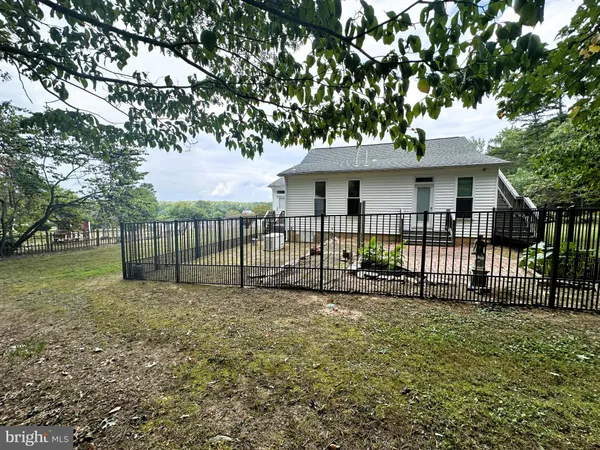 a view of a house with a small yard and a large tree