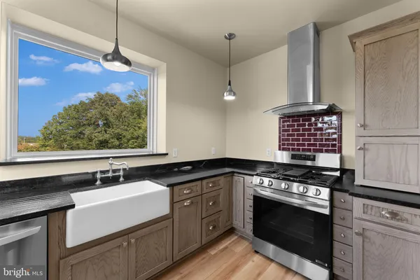 a kitchen with stainless steel appliances a stove sink and cabinets