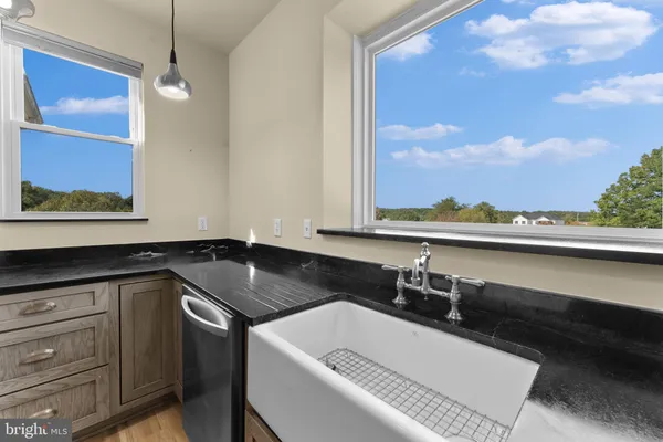 a kitchen with granite countertop a sink and dishwasher a stove with wooden floor