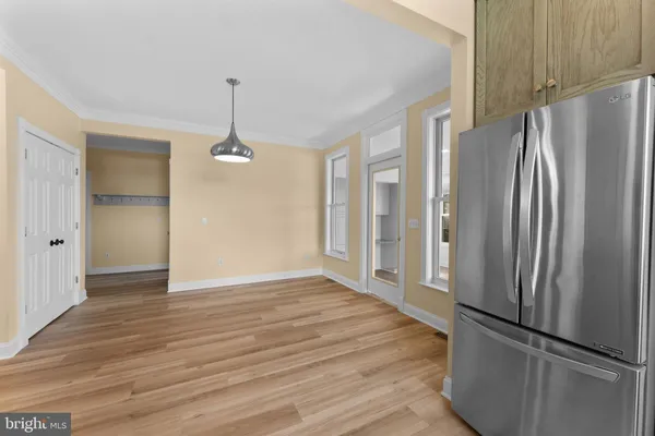 a view of a kitchen with wooden floor and a refrigerator