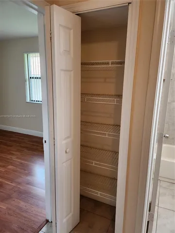 a view of walk in closet with empty racks