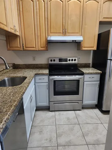 a kitchen with a stove top oven sink and cabinets