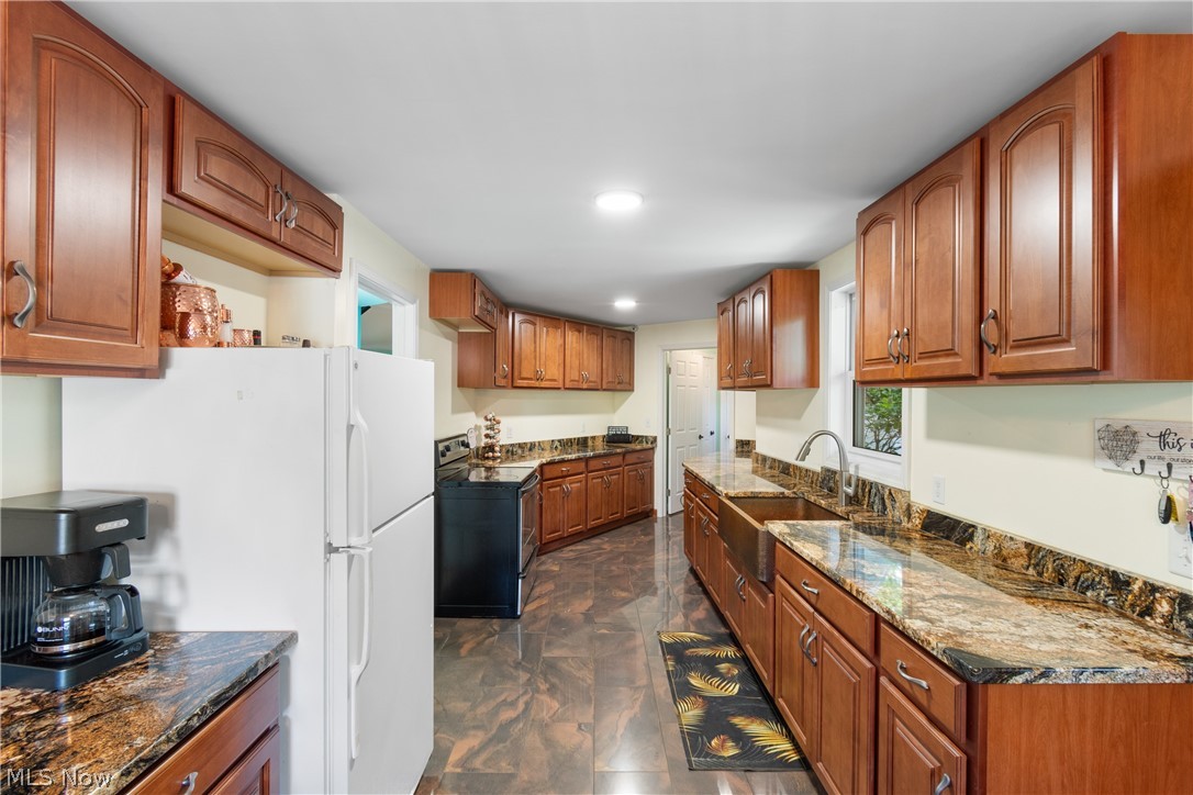 3255 Old Weymouth Road Medina, OH 44256 - Photo 10 of 31 Kitchen featuring white refrigerator, range with electric stovetop, dark tile flooring, dark stone countertops, and sink