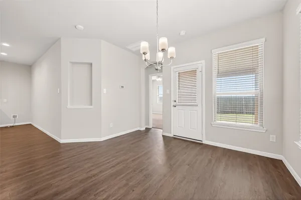 a kitchen with stainless steel appliances granite countertop a stove top oven a sink a refrigerator white cabinets and wooden floor