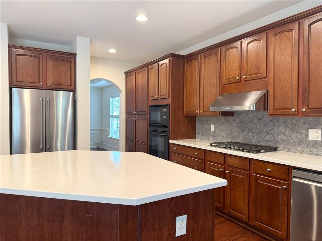 3240 Bentbill Crossing Cumming, GA 30041 - Photo 11 of 30 a kitchen with stainless steel appliances a refrigerator a sink a stove and wooden cabinets
