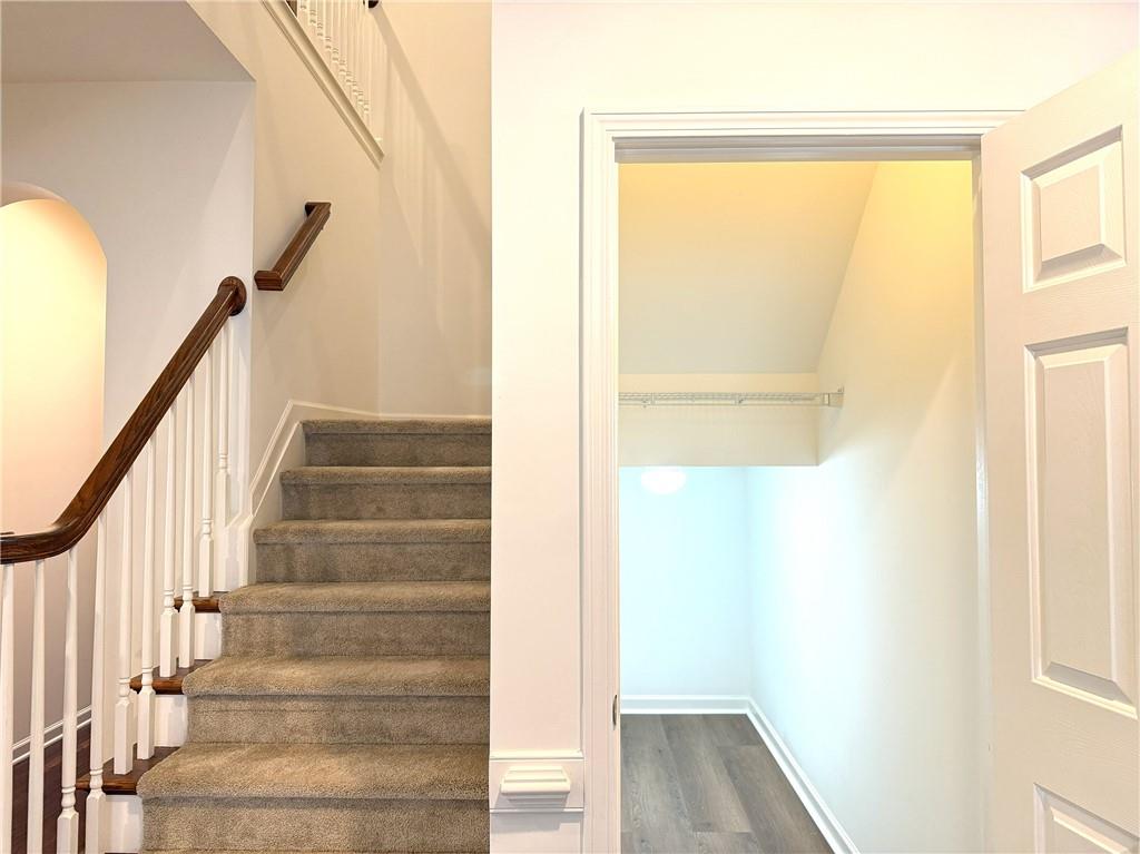 3240 Bentbill Crossing Cumming, GA 30041 - Photo 14 of 30 a view of staircase with wooden floor and white walls