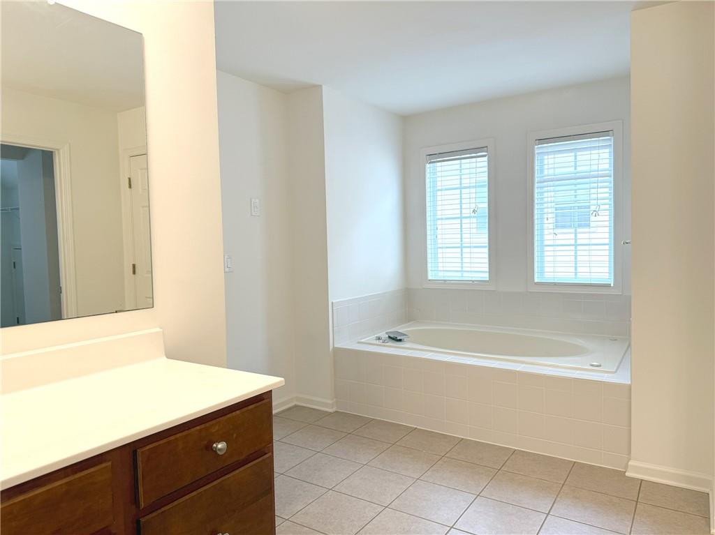 3240 Bentbill Crossing Cumming, GA 30041 - Photo 19 of 30 a spacious bathroom with a bathtub sink and mirror