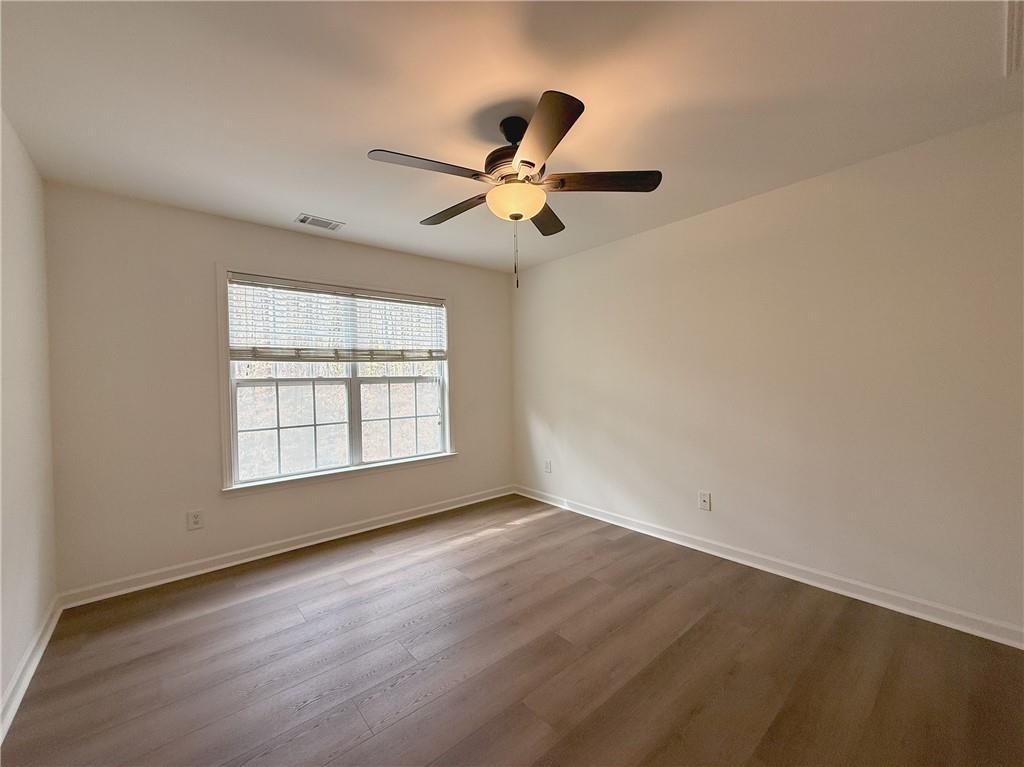 3240 Bentbill Crossing Cumming, GA 30041 - Photo 24 of 30 an empty room with wooden floor fan and windows