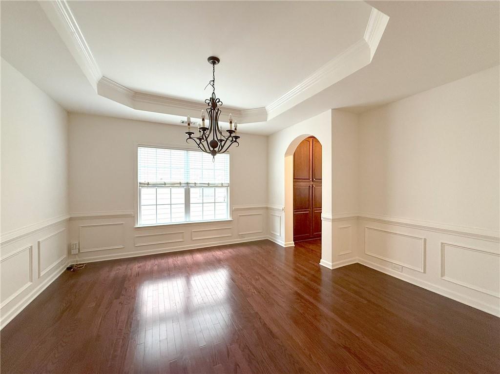 3240 Bentbill Crossing Cumming, GA 30041 - Photo 6 of 30 an empty room with wooden floor chandelier and windows