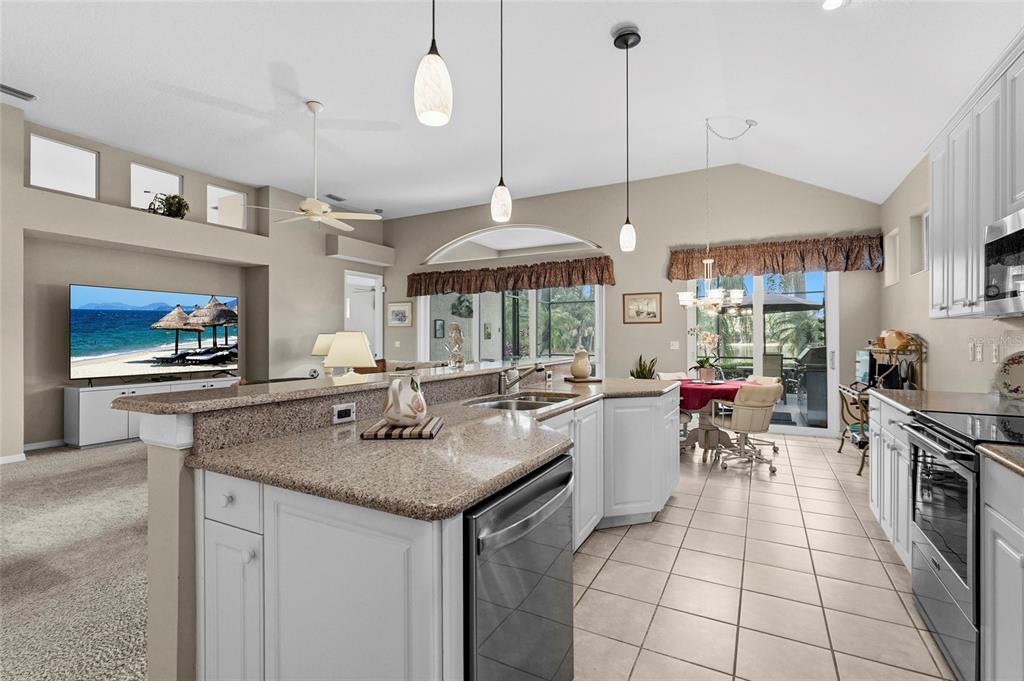 7822 Troon Court Lakewood Ranch, FL 34202 - Photo 23 of 83 a kitchen with a sink a stove and chairs