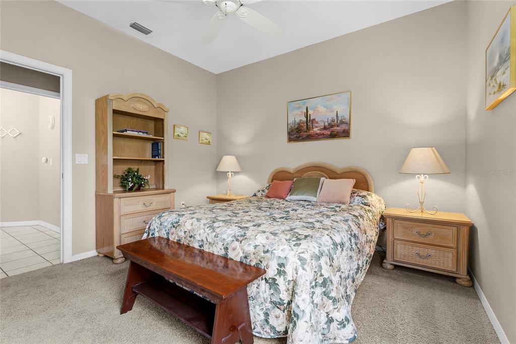 7822 Troon Court Lakewood Ranch, FL 34202 - Photo 38 of 83 a bedroom with a bed and a lamp on dresser