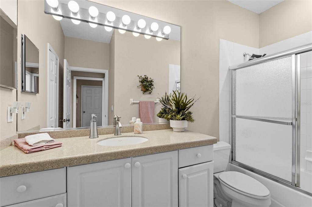 7822 Troon Court Lakewood Ranch, FL 34202 - Photo 39 of 83 a bathroom with a granite countertop sink a toilet and a mirror