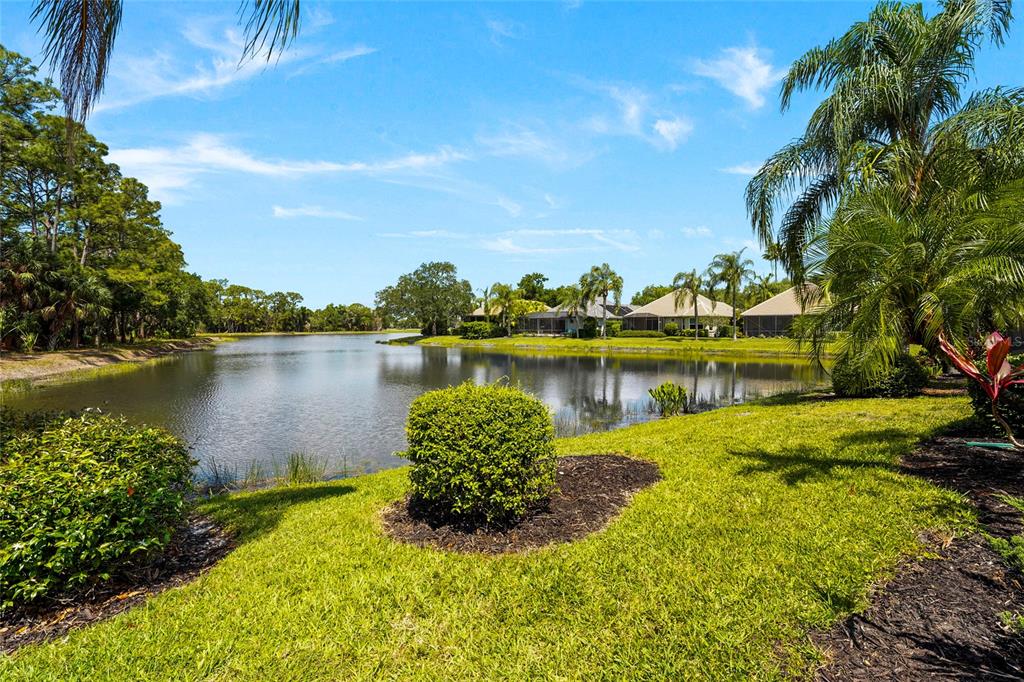 7822 Troon Court Lakewood Ranch, FL 34202 - Photo 50 of 83 a view of a lake with a house in the background