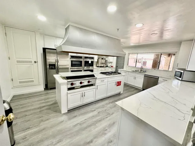 a kitchen with stainless steel appliances granite countertop a sink stove and refrigerator