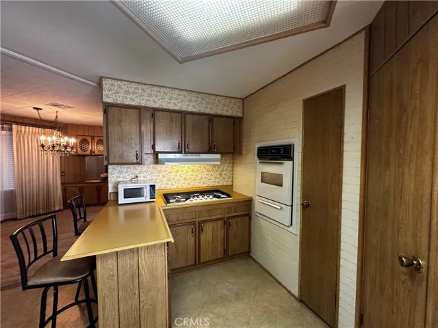a kitchen with a stove a refrigerator and furniture