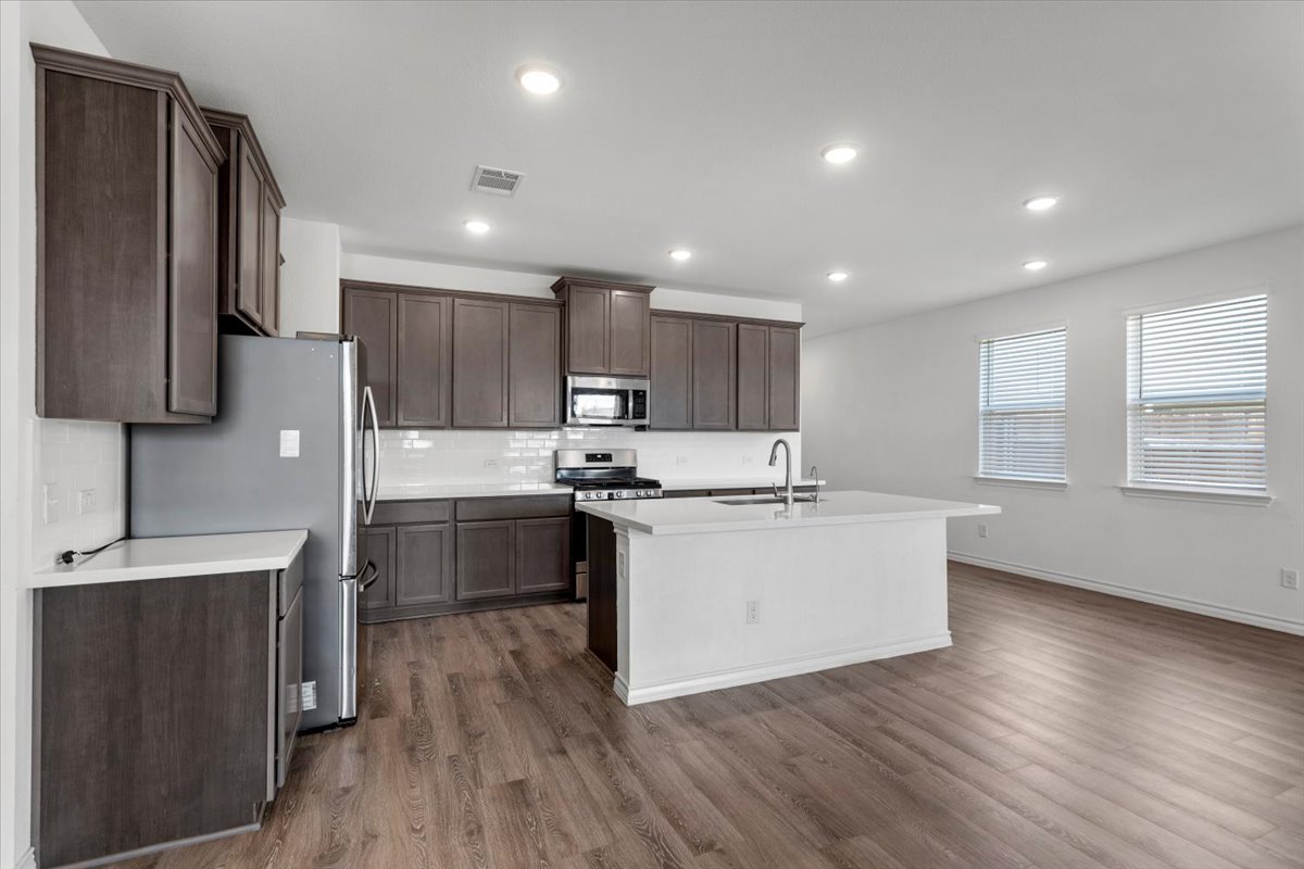 500 Stinchcomb Road Hutto, TX 78634 - Photo 15 of 37 A pristine kitchen with rich cabinetry and an inviting island, perfect for culinary endeavors.