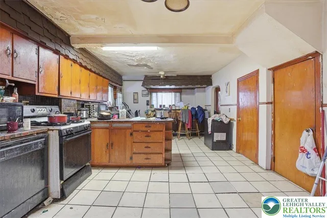 a kitchen with refrigerator a stove a sink and cabinets