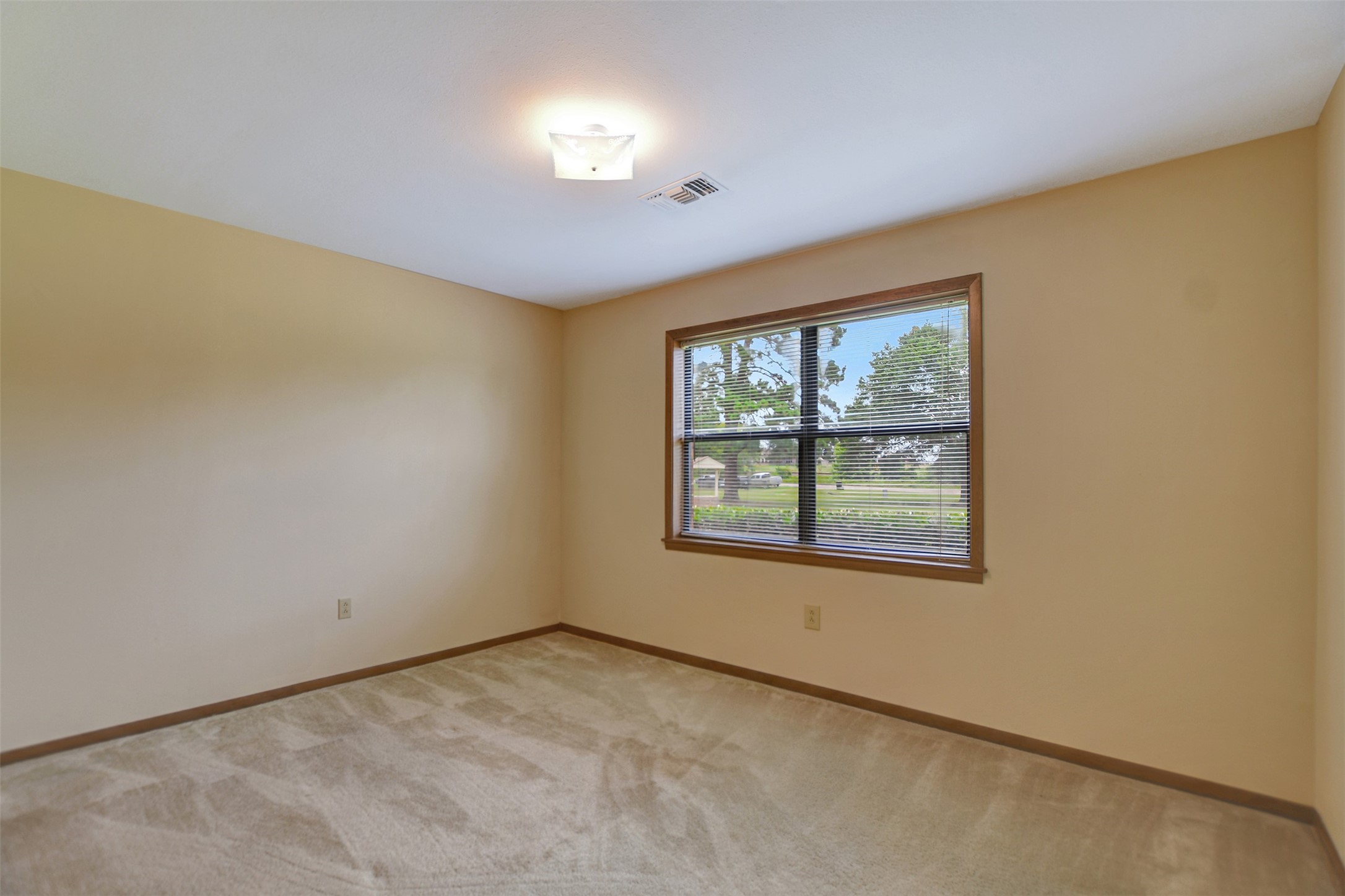 341 South S Loop Bellville, TX 77418 - Photo 25 of 33 This is a bright and spacious room featuring neutral walls and carpet. It has a large window offering a pleasant view and ample natural light, perfect for a bedroom or office space.