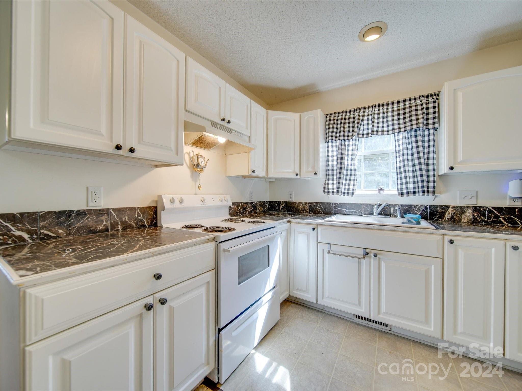 6312 Plyler Mill Road Monroe, NC 28112 - Photo 27 of 41 a kitchen with granite countertop white cabinets and white appliances