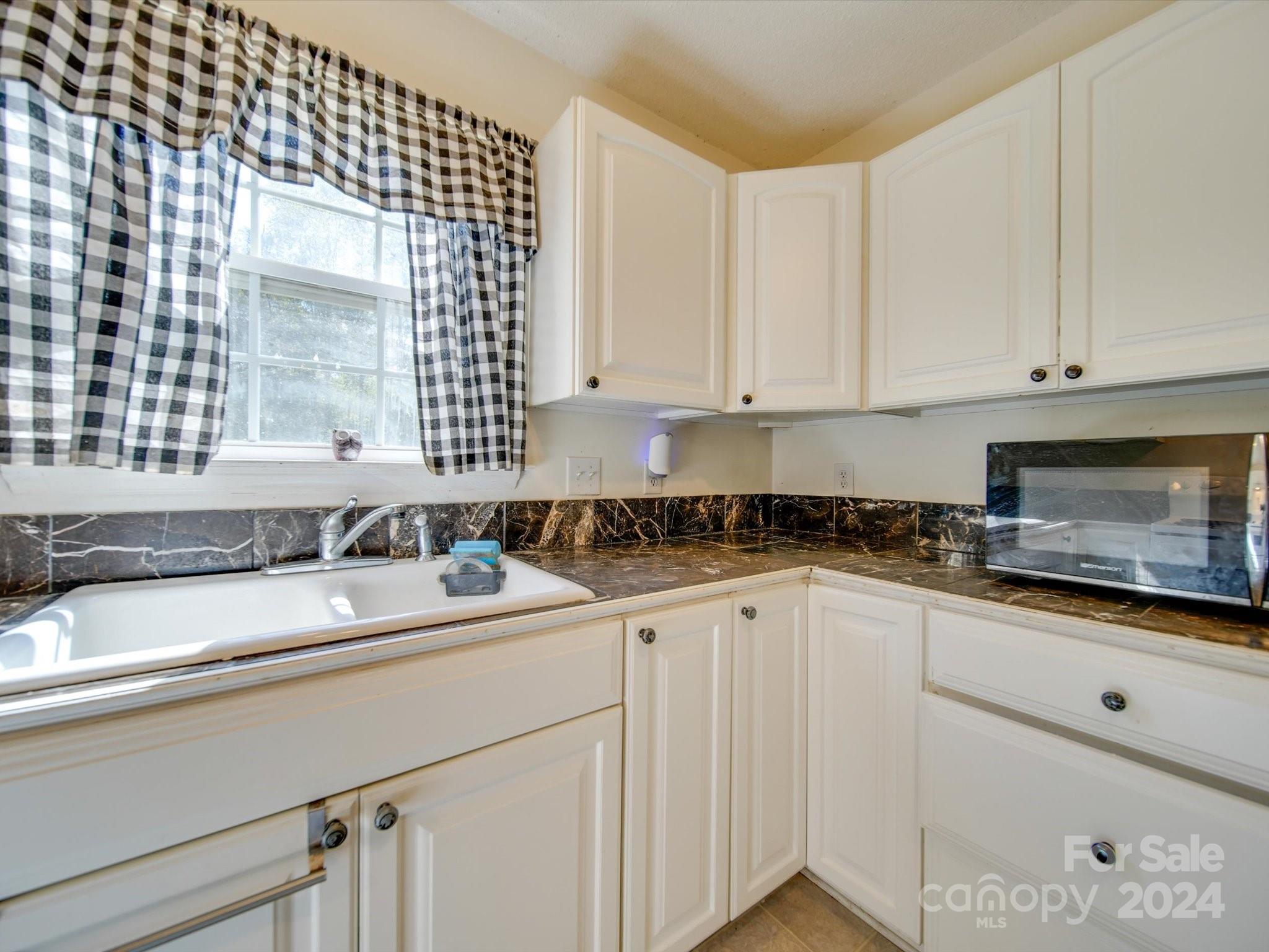 6312 Plyler Mill Road Monroe, NC 28112 - Photo 29 of 41 a kitchen with granite countertop a sink and a white cabinets