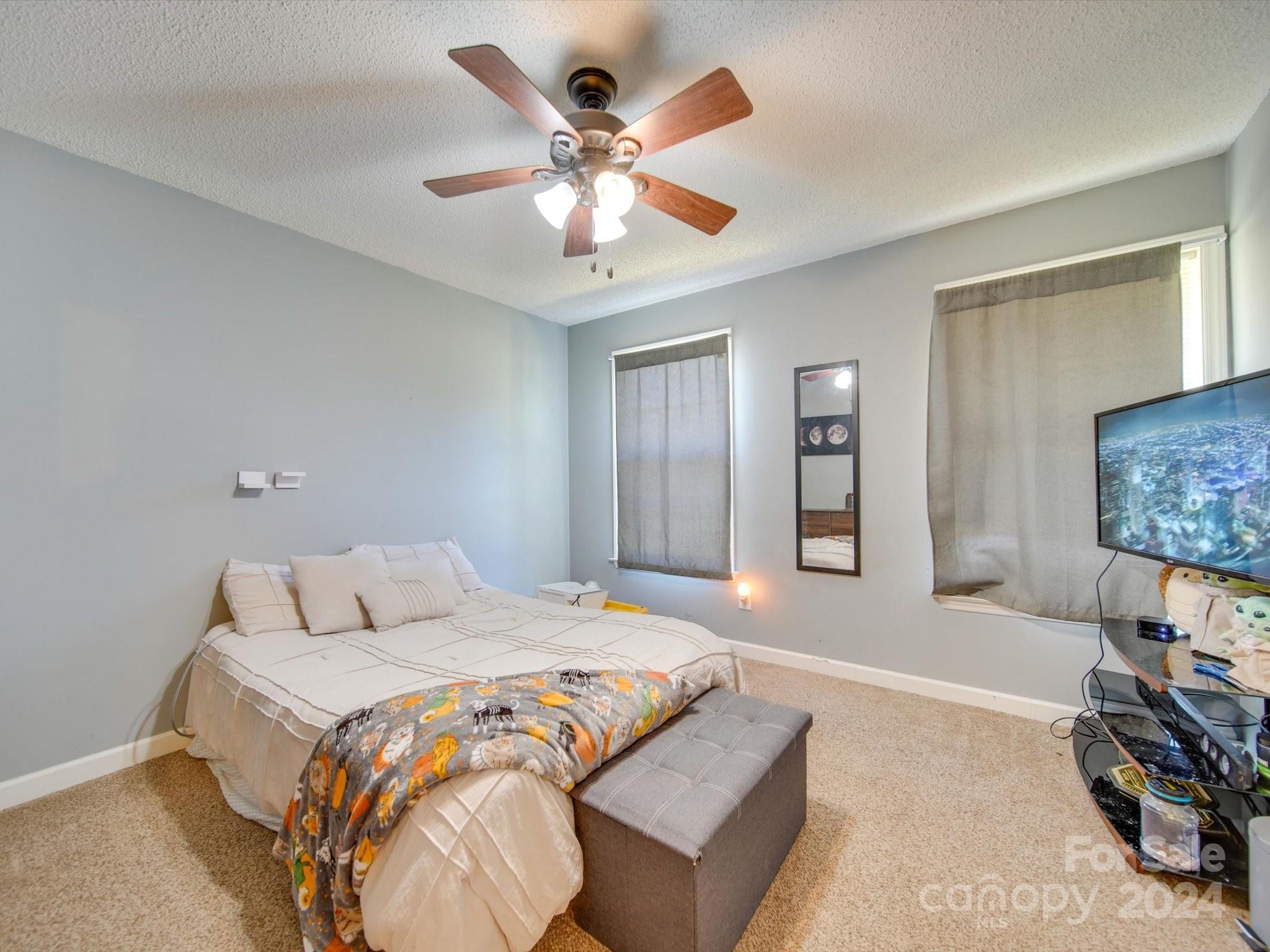 6312 Plyler Mill Road Monroe, NC 28112 - Photo 36 of 41 a bedroom with a large bed and a ceiling fan