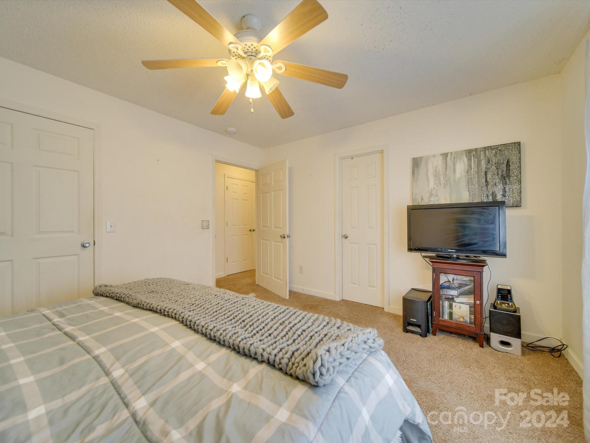 6312 Plyler Mill Road Monroe, NC 28112 - Photo 38 of 41 a bedroom with a bed and a flat tv screen on wall