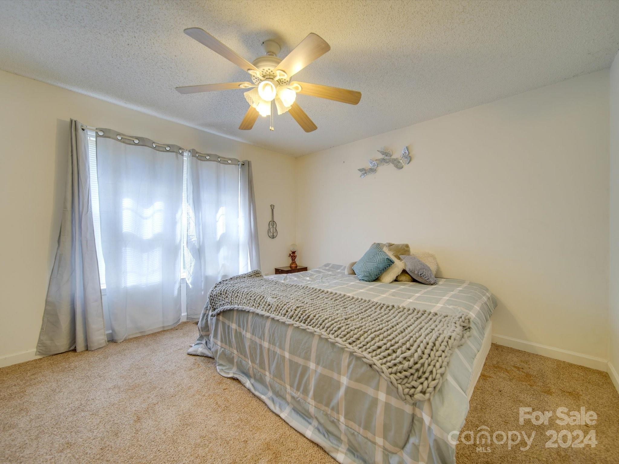 6312 Plyler Mill Road Monroe, NC 28112 - Photo 39 of 41 a bedroom with a bed and a chandelier
