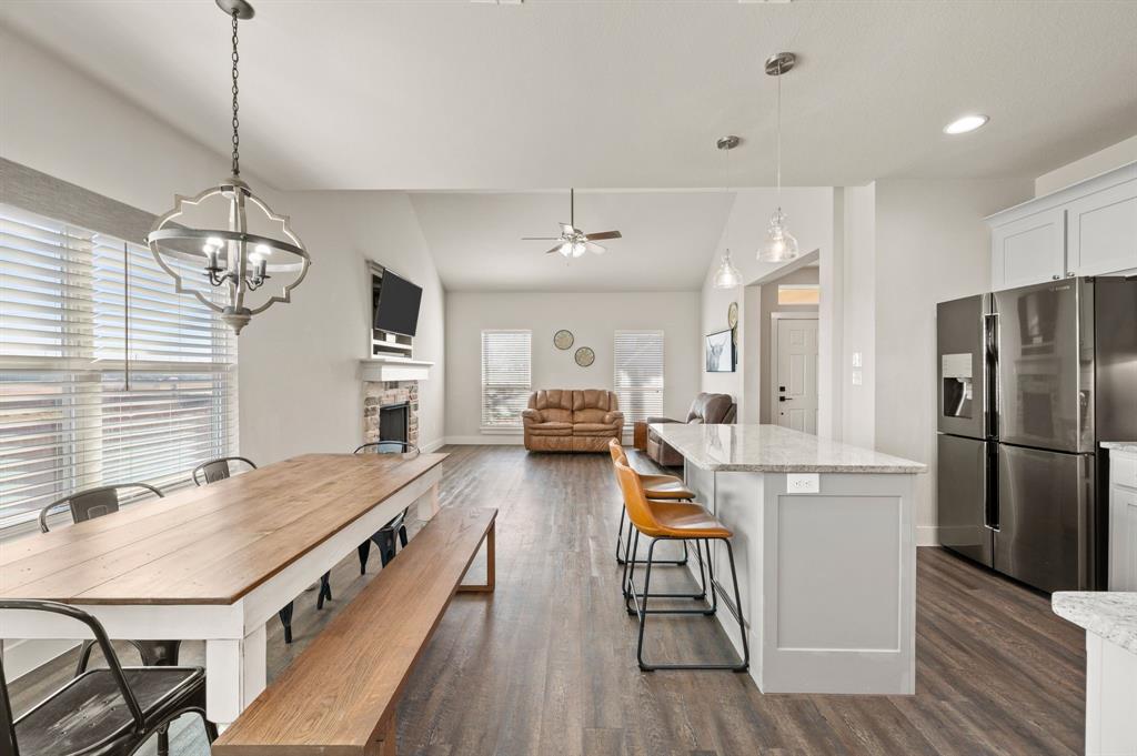 824 East Northside Drive Pilot Point, TX 76258 - Photo 11 of 23 a kitchen with stainless steel appliances a dining table chairs stove refrigerator and cabinets