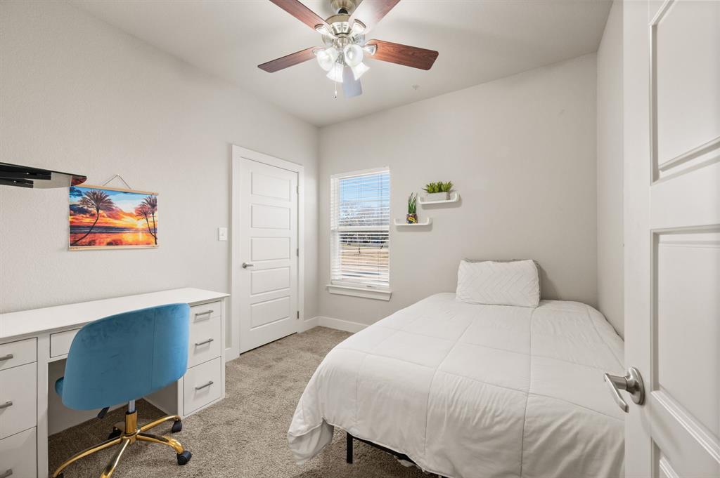 824 East Northside Drive Pilot Point, TX 76258 - Photo 16 of 23 a bedroom with a bed and a chandelier