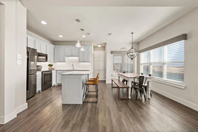 a kitchen with a table chairs refrigerator and chairs