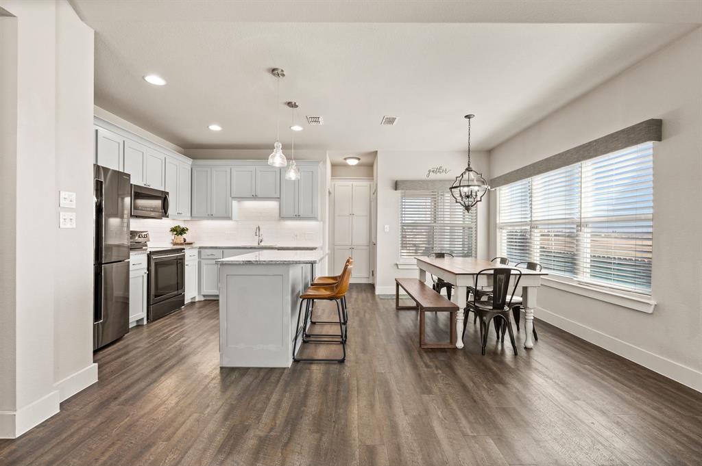 824 East Northside Drive Pilot Point, TX 76258 - Photo 6 of 23 a kitchen with a table chairs refrigerator and chairs