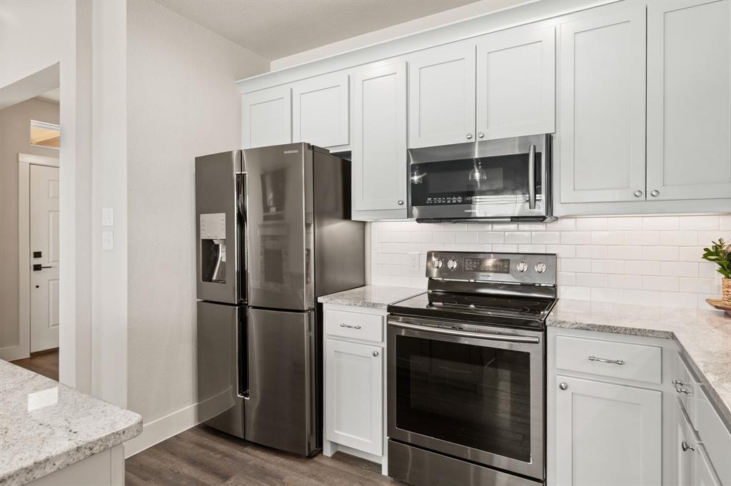 824 East Northside Drive Pilot Point, TX 76258 - Photo 8 of 23 a kitchen with a stove microwave and refrigerator