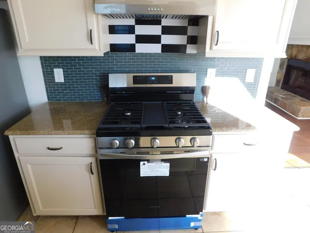 a stove top oven sitting inside of a kitchen