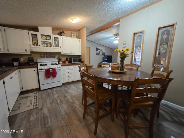 a kitchen with a stove a table and chairs in it
