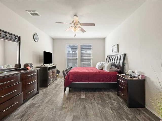 a spacious bedroom with a bed and a flat screen tv